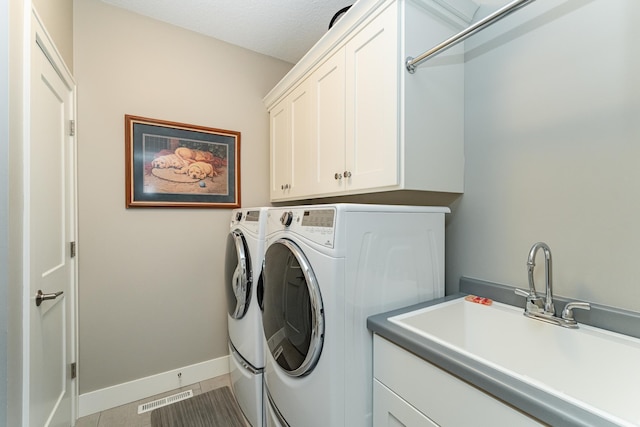 1062 Fox Hill Ln SW, Rochester, MN 55902 - washroom featuring cabinet space, separate washer and dryer, and tile patterned flooring