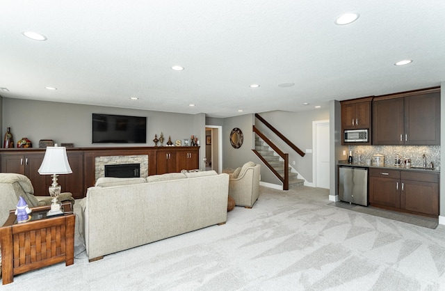 1062 Fox Hill Ln SW, Rochester, MN 55902 - living area with wet bar, light carpet, recessed lighting, stairway, and a stone fireplace
