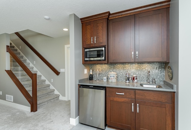 1062 Fox Hill Ln SW, Rochester, MN 55902 - indoor wet bar featuring stainless steel appliances, light carpet, tasteful backsplash, stairway, and recessed lighting