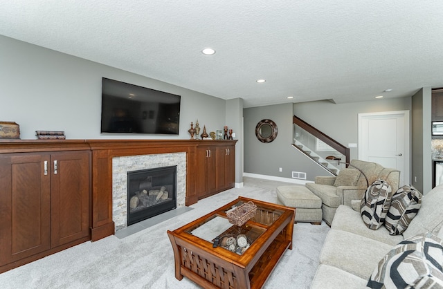 1062 Fox Hill Ln SW, Rochester, MN 55902 - living area featuring light carpet, stairs, a textured ceiling, recessed lighting, and a fireplace with flush hearth