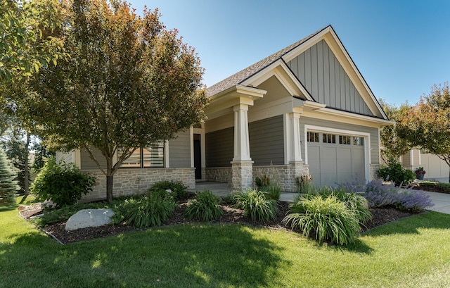 1062 Fox Hill Ln SW, Rochester, MN 55902 - view of side of property featuring board and batten siding, covered porch, a yard, stone siding, and a garage