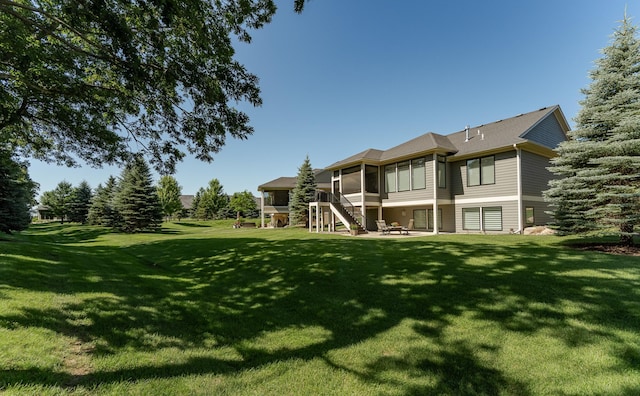 1062 Fox Hill Ln SW, Rochester, MN 55902 - rear view of property with a sunroom, a yard, stairs, and a patio