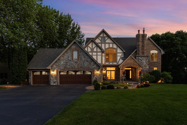 11193 Bluestem Ln, Eden Prairie, MN 55347 - tudor home featuring stone siding, a chimney, driveway, an attached garage, and a front lawn