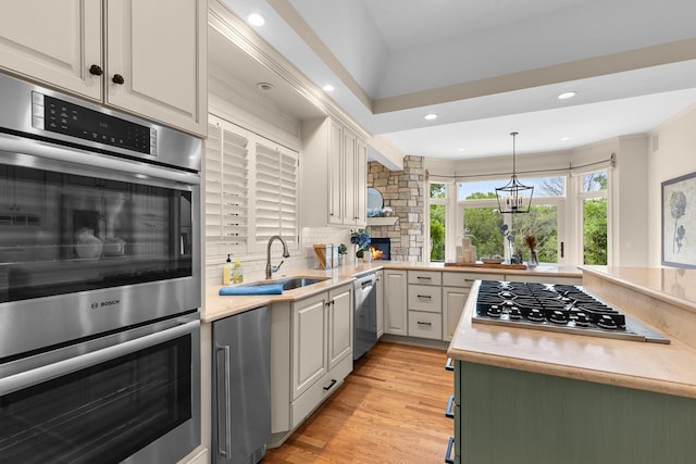 11193 Bluestem Ln, Eden Prairie, MN 55347 - kitchen featuring stainless steel appliances, light countertops, decorative backsplash, light wood-style floors, and decorative light fixtures