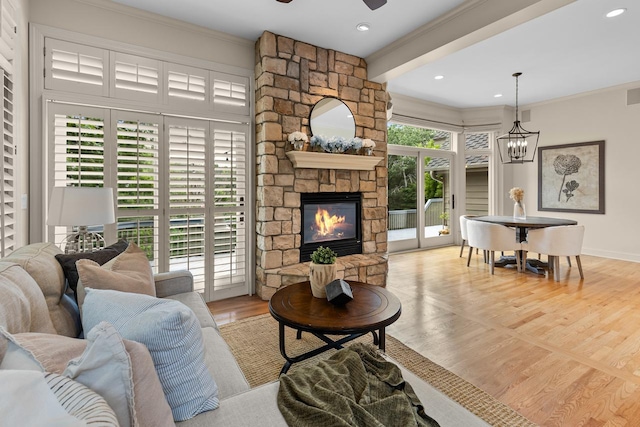 11193 Bluestem Ln, Eden Prairie, MN 55347 - living room with crown molding, a ceiling fan, a stone fireplace, a chandelier, and wood finished floors