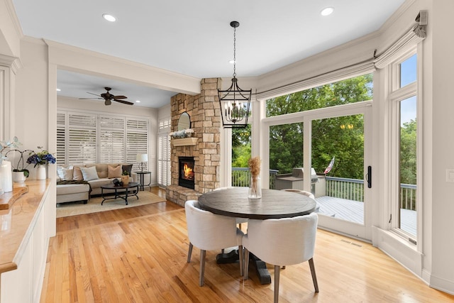11193 Bluestem Ln, Eden Prairie, MN 55347 - dining space with plenty of natural light, light wood-style flooring, a fireplace, recessed lighting, and crown molding