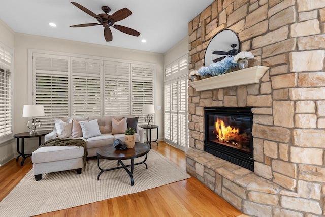 11193 Bluestem Ln, Eden Prairie, MN 55347 - living area featuring a ceiling fan, a stone fireplace, wood finished floors, and ornamental molding