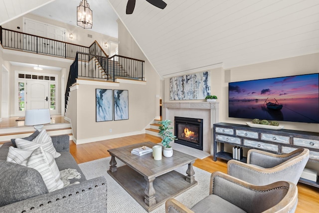 11193 Bluestem Ln, Eden Prairie, MN 55347 - living room featuring stairs, wood finished floors, high vaulted ceiling, a ceiling fan, and a fireplace with flush hearth