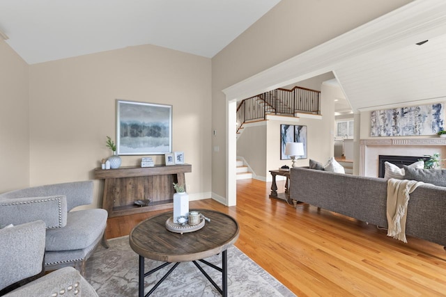 11193 Bluestem Ln, Eden Prairie, MN 55347 - living room featuring a fireplace, lofted ceiling, stairway, and wood finished floors