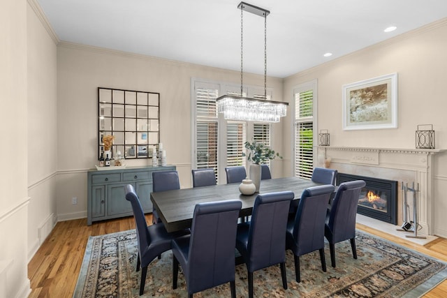 11193 Bluestem Ln, Eden Prairie, MN 55347 - dining space featuring a chandelier, crown molding, light wood-style flooring, a fireplace with flush hearth, and recessed lighting