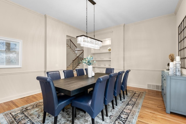 11193 Bluestem Ln, Eden Prairie, MN 55347 - dining space with a chandelier, light wood-style flooring, ornamental molding, and stairs