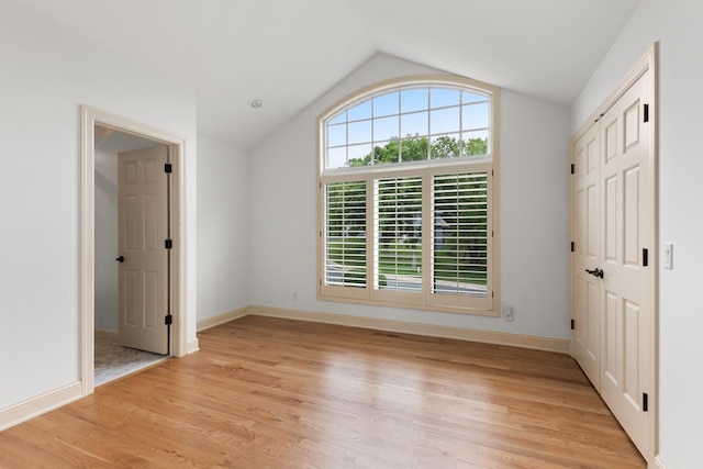 11193 Bluestem Ln, Eden Prairie, MN 55347 - empty room featuring vaulted ceiling and light wood-style flooring