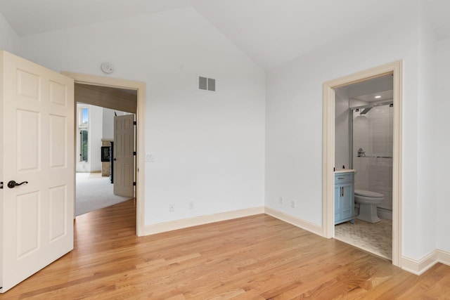 11193 Bluestem Ln, Eden Prairie, MN 55347 - unfurnished bedroom featuring vaulted ceiling, light wood-style flooring, and ensuite bath