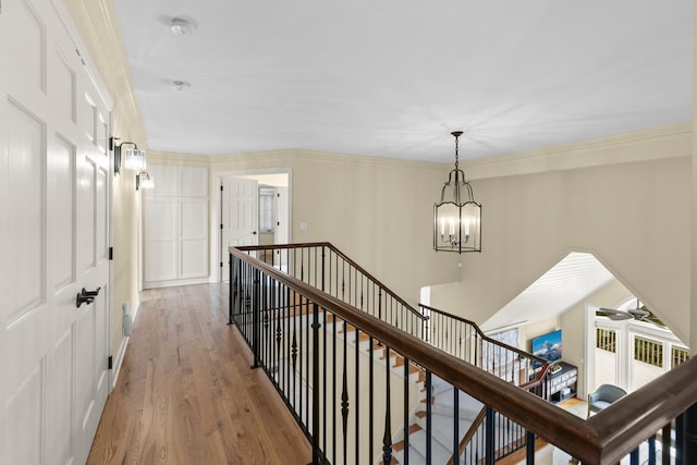 11193 Bluestem Ln, Eden Prairie, MN 55347 - hallway with an upstairs landing, a chandelier, wood finished floors, and ornamental molding