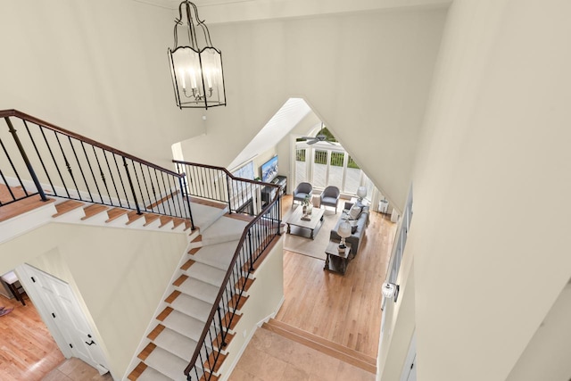 11193 Bluestem Ln, Eden Prairie, MN 55347 - staircase with a towering ceiling, a ceiling fan, a chandelier, and wood finished floors