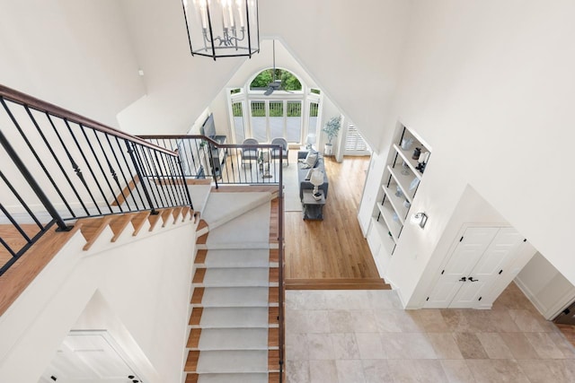 11193 Bluestem Ln, Eden Prairie, MN 55347 - stairway with a high ceiling, ceiling fan, and a chandelier