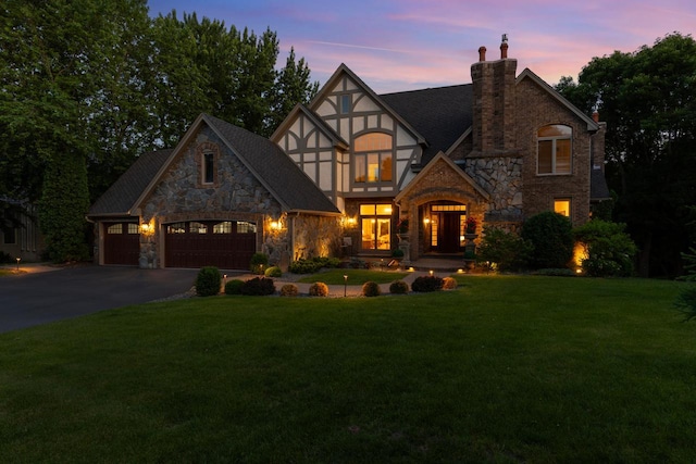 11193 Bluestem Ln, Eden Prairie, MN 55347 - tudor home featuring stone siding, a chimney, a yard, and driveway
