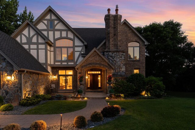 11193 Bluestem Ln, Eden Prairie, MN 55347 - english style home featuring stone siding, a front yard, a chimney, and stucco siding