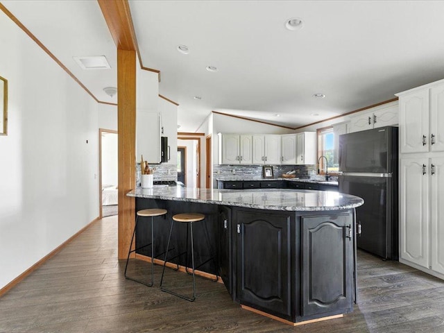 33498 175th St NE, Morrill Twp, MN 56329 - kitchen with freestanding refrigerator, a peninsula, decorative backsplash, white cabinets, and light stone countertops