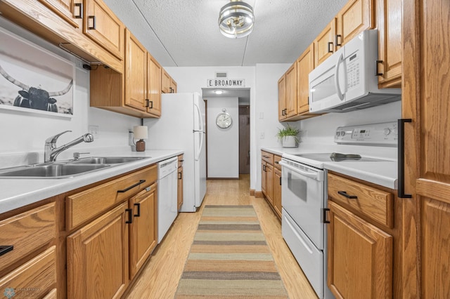 1110 3rd Ave N Unit 201E, Fargo, ND 58102 - kitchen with white appliances, light wood-style flooring, a textured ceiling, light countertops, and brown cabinets