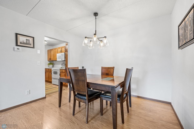 1110 3rd Ave N Unit 201E, Fargo, ND 58102 - dining area with light wood-style flooring, a chandelier, and a textured ceiling