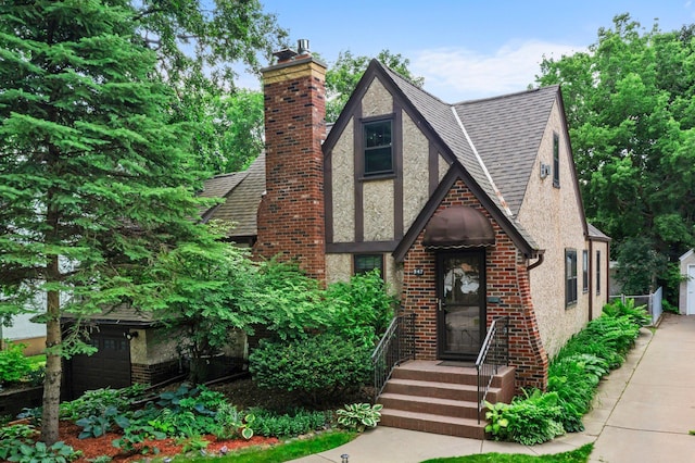 947 Stryker Ave W, Saint Paul, MN 55118 - english style home with a shingled roof, stucco siding, a chimney, brick siding, and a garage