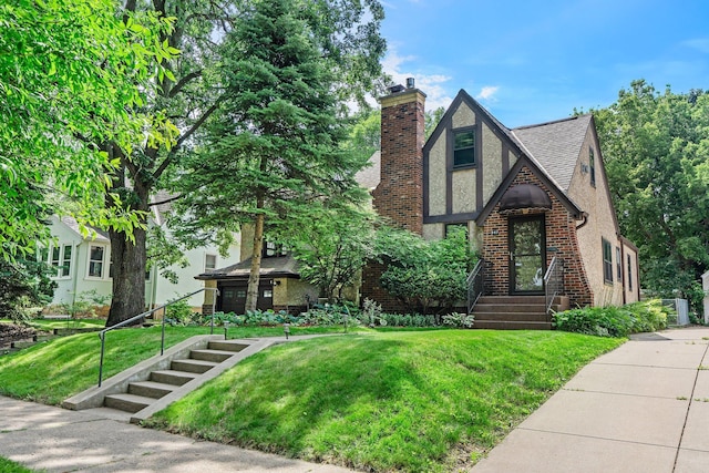 947 Stryker Ave W, Saint Paul, MN 55118 - english style home featuring a chimney, roof with shingles, and a front yard