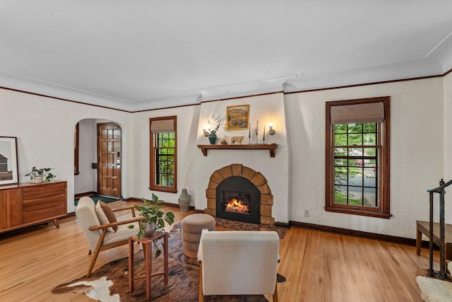 947 Stryker Ave W, Saint Paul, MN 55118 - living area featuring wood finished floors, a warm lit fireplace, arched walkways, and crown molding