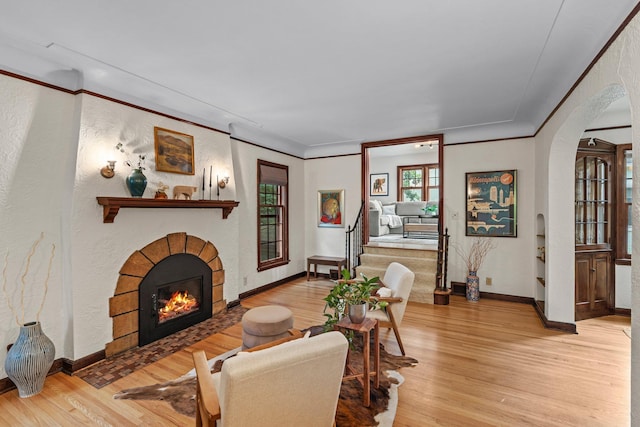 947 Stryker Ave W, Saint Paul, MN 55118 - living room featuring arched walkways, light wood-type flooring, a fireplace with flush hearth, ornamental molding, and a textured wall