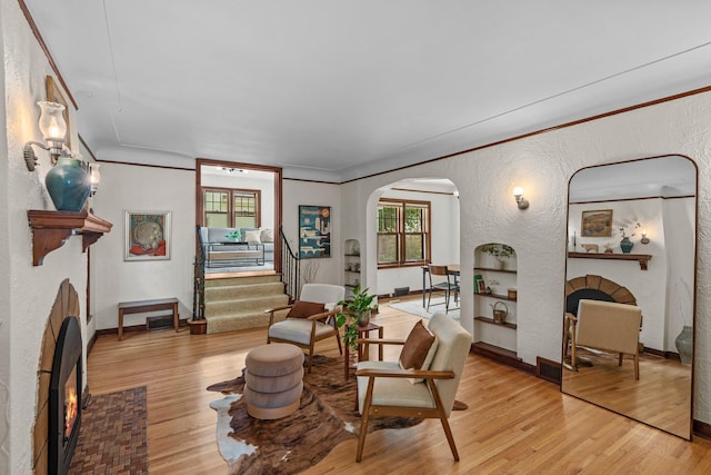 947 Stryker Ave W, Saint Paul, MN 55118 - living room with a fireplace, ornamental molding, arched walkways, light wood-style floors, and a textured wall