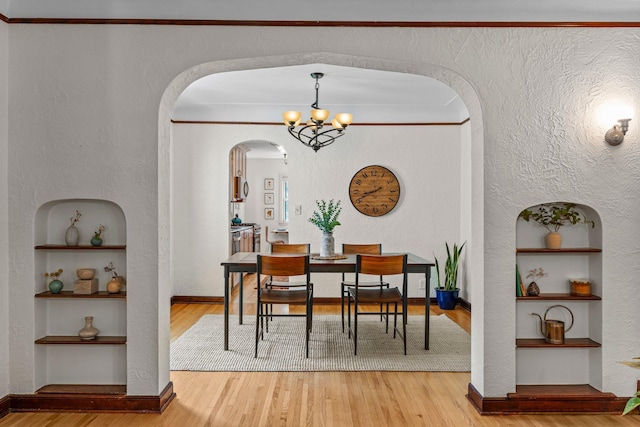 947 Stryker Ave W, Saint Paul, MN 55118 - dining area with built in shelves, arched walkways, a chandelier, wood finished floors, and a textured wall