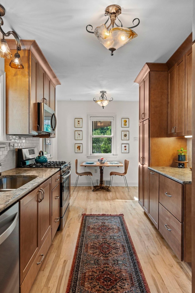 947 Stryker Ave W, Saint Paul, MN 55118 - kitchen with appliances with stainless steel finishes, tasteful backsplash, light wood-style flooring, and light stone counters