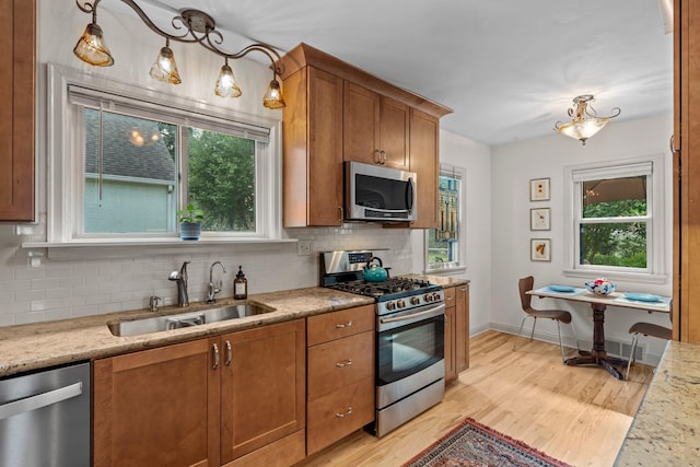 947 Stryker Ave W, Saint Paul, MN 55118 - kitchen with appliances with stainless steel finishes, brown cabinetry, decorative backsplash, and plenty of natural light