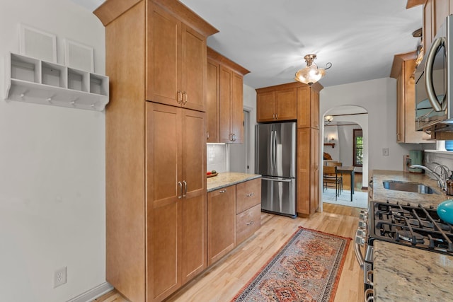 947 Stryker Ave W, Saint Paul, MN 55118 - kitchen with stainless steel appliances, arched walkways, light wood-style flooring, and light stone countertops