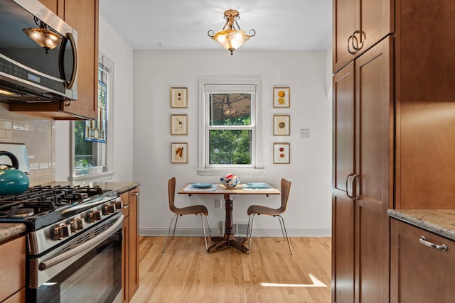 947 Stryker Ave W, Saint Paul, MN 55118 - kitchen featuring appliances with stainless steel finishes, light wood finished floors, light stone counters, decorative backsplash, and brown cabinets