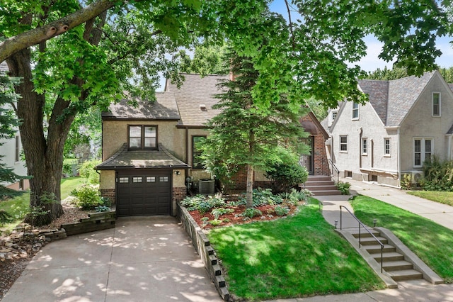 947 Stryker Ave W, Saint Paul, MN 55118 - tudor home featuring brick siding, driveway, stucco siding, a garage, and a front lawn
