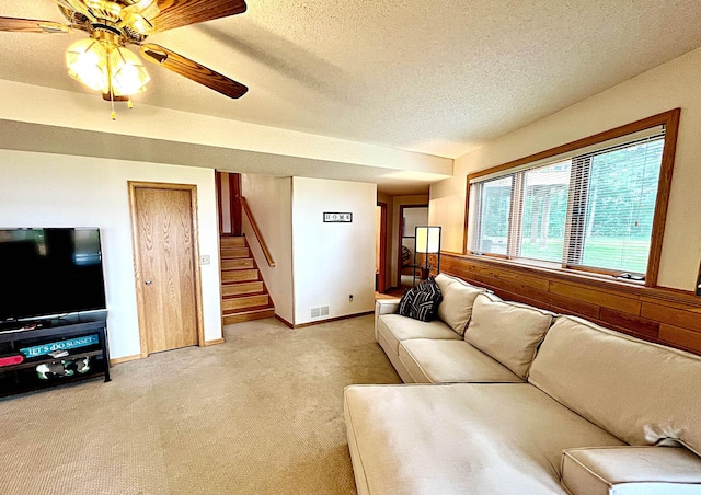 44512 276th Ln, Aitkin, MN 56431 - living room featuring stairway, light colored carpet, a textured ceiling, and a ceiling fan