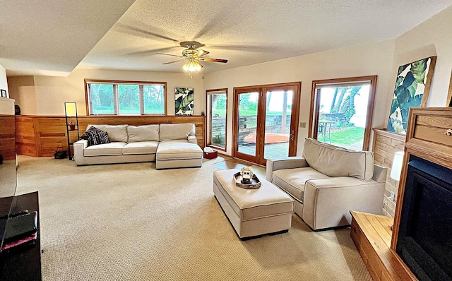 44512 276th Ln, Aitkin, MN 56431 - living room featuring light carpet, a ceiling fan, a textured ceiling, and a fireplace with raised hearth