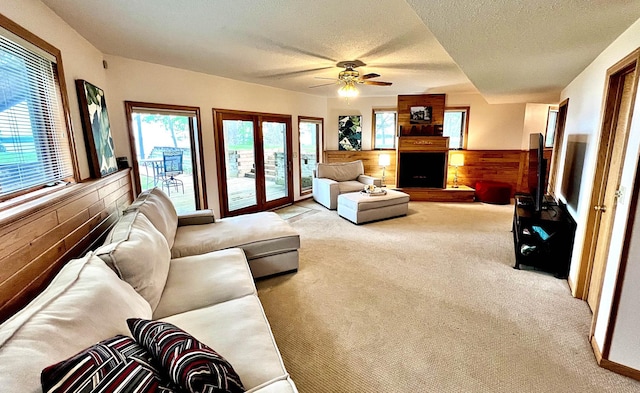 44512 276th Ln, Aitkin, MN 56431 - living area featuring light carpet, a textured ceiling, ceiling fan, wooden walls, and a wainscoted wall