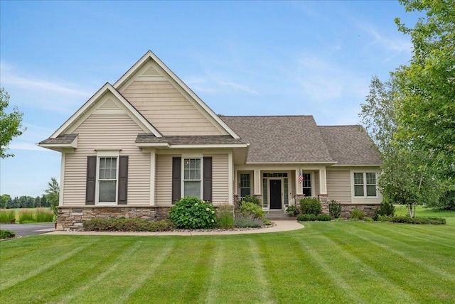 238 Muirfield Trl, Hudson, WI 54016 - view of front of house with a front lawn, stone siding, and roof with shingles