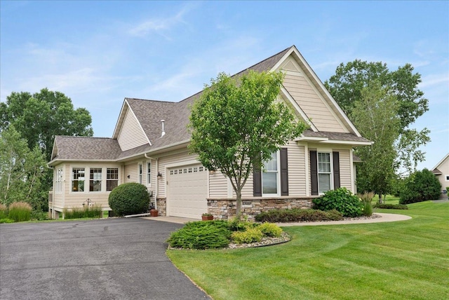 238 Muirfield Trl, Hudson, WI 54016 - view of front of home with an attached garage, driveway, roof with shingles, a front yard, and stone siding