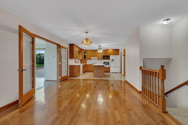 42767 190th Ave, Holding Twp, MN 56340 - kitchen with white appliances, light countertops, light wood-style floors, and brown cabinets