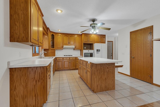 42767 190th Ave, Holding Twp, MN 56340 - kitchen with under cabinet range hood, gas cooktop, a ceiling fan, a center island, and glass insert cabinets