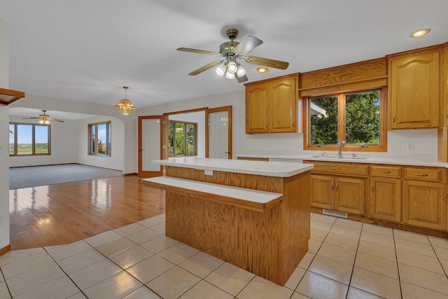 42767 190th Ave, Holding Twp, MN 56340 - kitchen featuring light countertops, a ceiling fan, a kitchen island, light tile patterned floors, and open floor plan