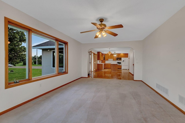 42767 190th Ave, Holding Twp, MN 56340 - unfurnished living room featuring arched walkways, a ceiling fan, light colored carpet, and a chandelier
