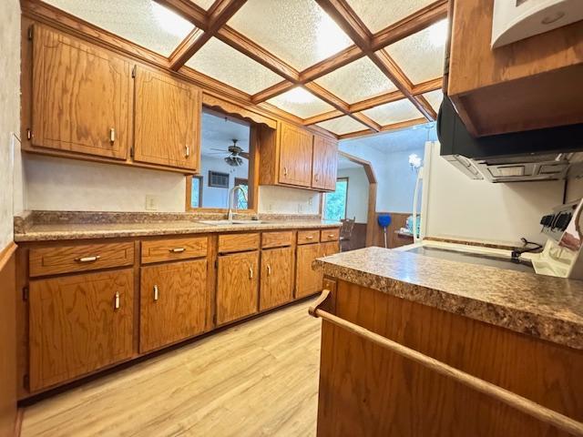 517 2nd St NW, Menahga, MN 56464 - kitchen with brown cabinetry, light wood-style flooring, and coffered ceiling