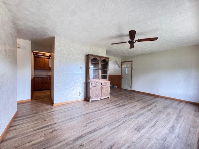 517 2nd St NW, Menahga, MN 56464 - empty room featuring wood finished floors, a ceiling fan, a textured ceiling, and a textured wall