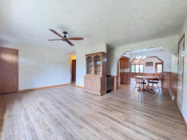 517 2nd St NW, Menahga, MN 56464 - unfurnished living room with a textured ceiling, light wood finished floors, a baseboard heating unit, ceiling fan, and a chandelier
