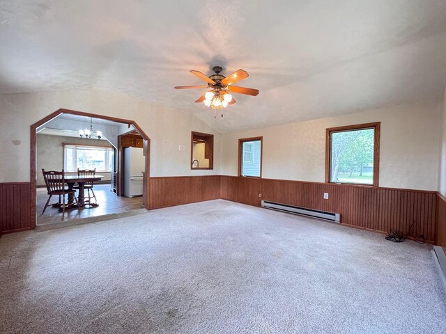 517 2nd St NW, Menahga, MN 56464 - empty room with a baseboard heating unit, wainscoting, plenty of natural light, light colored carpet, and lofted ceiling