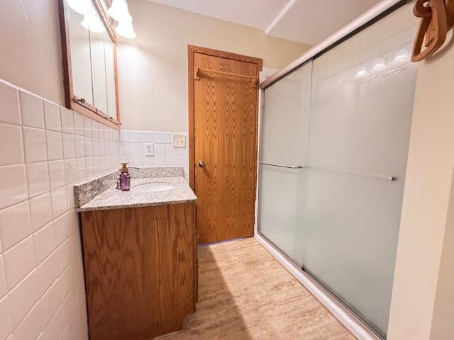 517 2nd St NW, Menahga, MN 56464 - bathroom featuring vanity, a stall shower, and wood finished floors